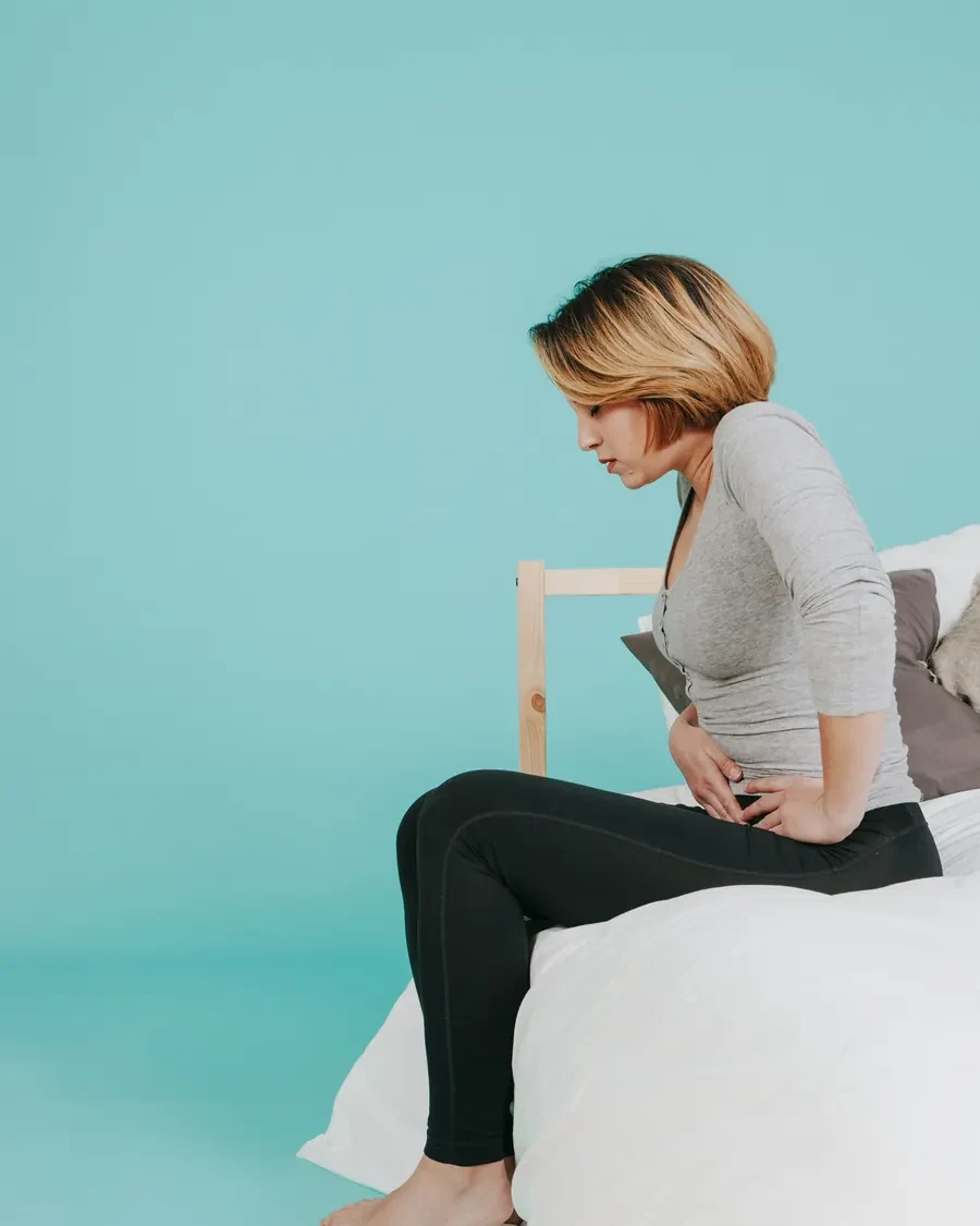 Mulher com as mãos na barriga, sensação de inchaço